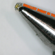A photo of a tiny crab-like robot on the end of a pen with the caption "smallest robot in the word".